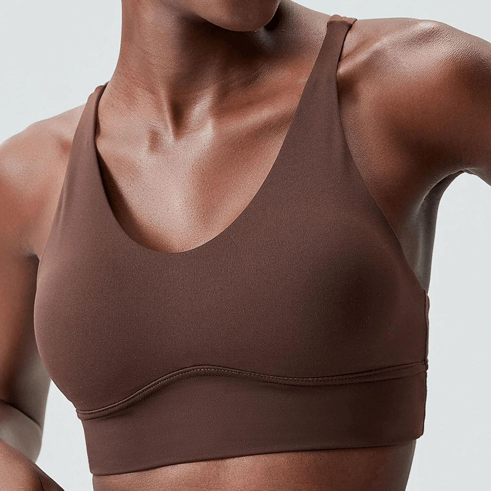 Woman wearing dark brown sports bra with deep V-neck design for workouts and yoga.